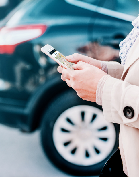 woman hold cell phone near car